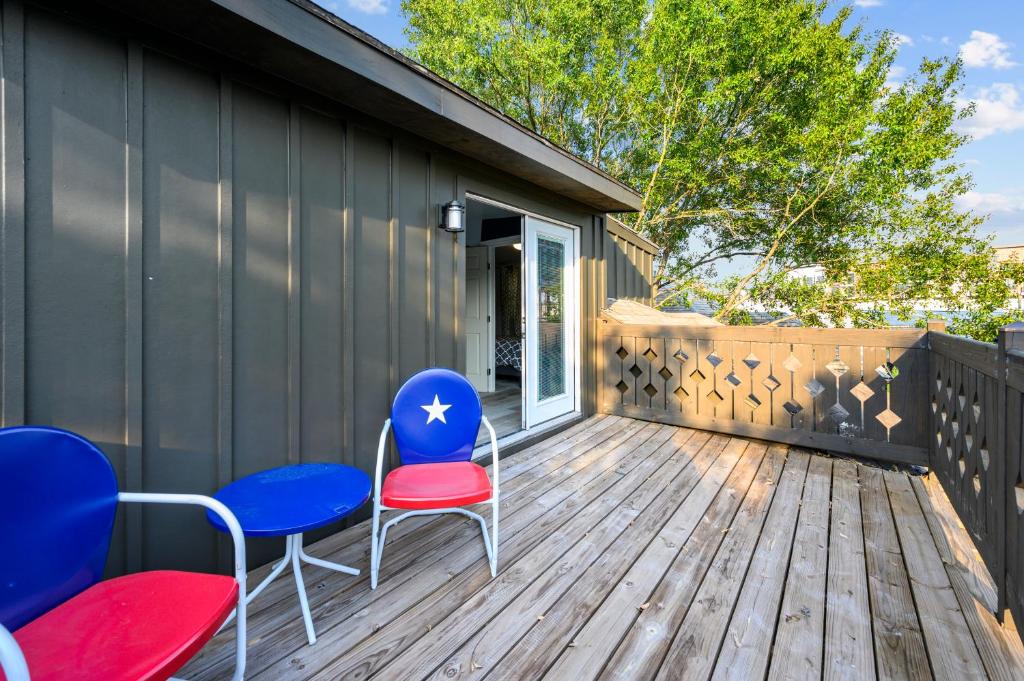 a deck with blue and red chairs and a house at Cozy & Spacious Montrose Retreat with 3BR Near Houston Attractions in Houston