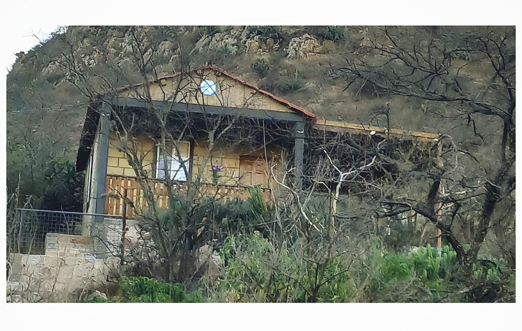 a small house on the side of a mountain at Cabaña de Descanso El garambullo in San Antonio de la Cal
