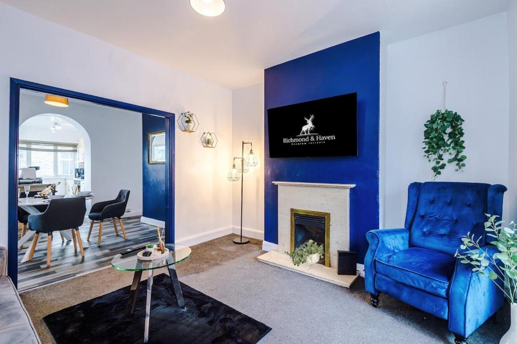 a living room with a blue couch and a fireplace at Charming 2 Bed House, Sleeps 6, Free parking, Contractors welcome in Elland