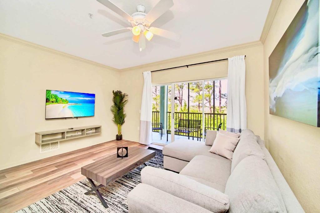 a living room with a couch and a tv at Near Disney - Spacious 3BR Condo with Pool in Orlando