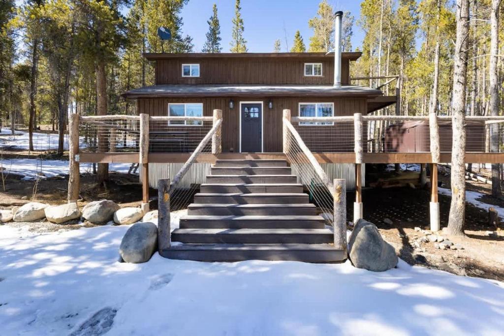 a house in the snow with stairs leading to it at Mountain Cabin wHot Tub & Washer Dryer in Fairplay