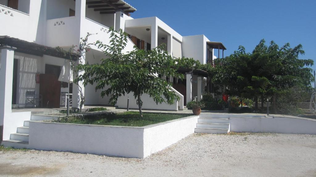 um edifício branco com árvores em frente em Eleana Studios em Skiros