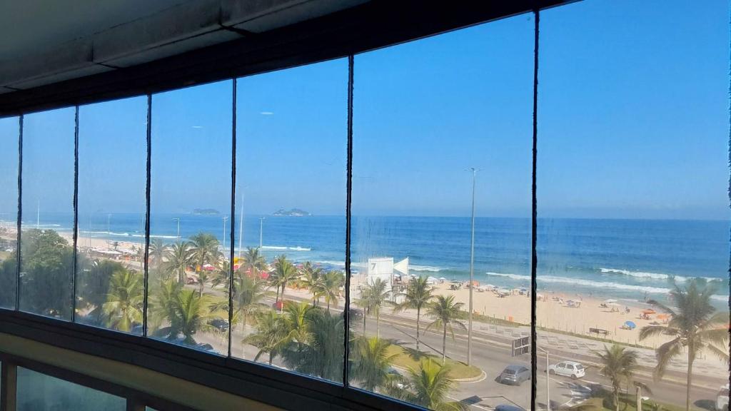 una ventana del hotel con vistas a la playa en Flat Residencial Praia da Barra, Piscina e Sauna - Frente Mar D68508, en Río de Janeiro