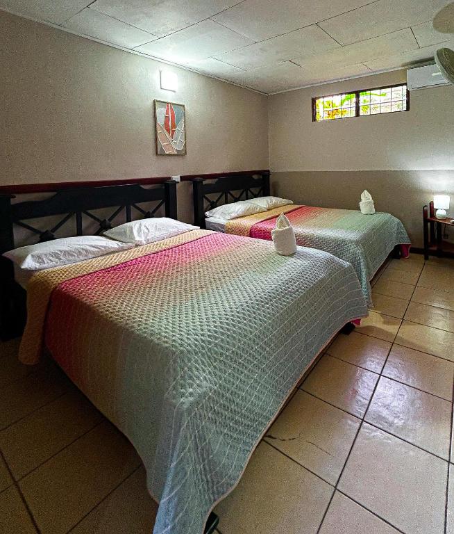 two beds sitting in a room with at Cabinas Ole Caribe in Puerto Viejo
