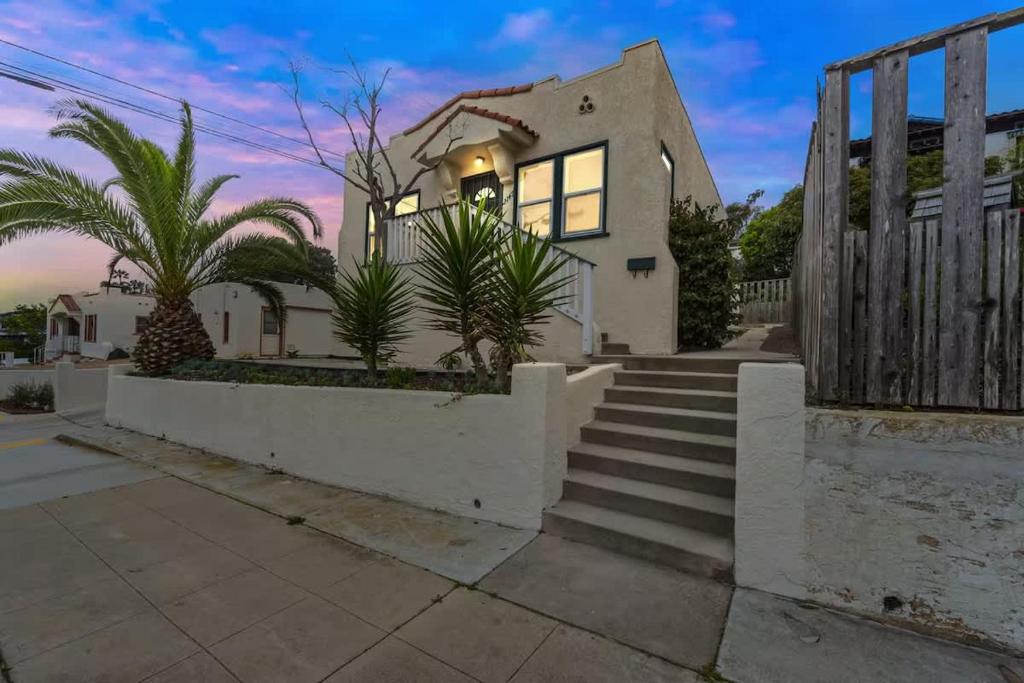 ein weißes Haus mit Palmen und Treppen in der Unterkunft Cozy Ocean Beach Bungalow in San Diego