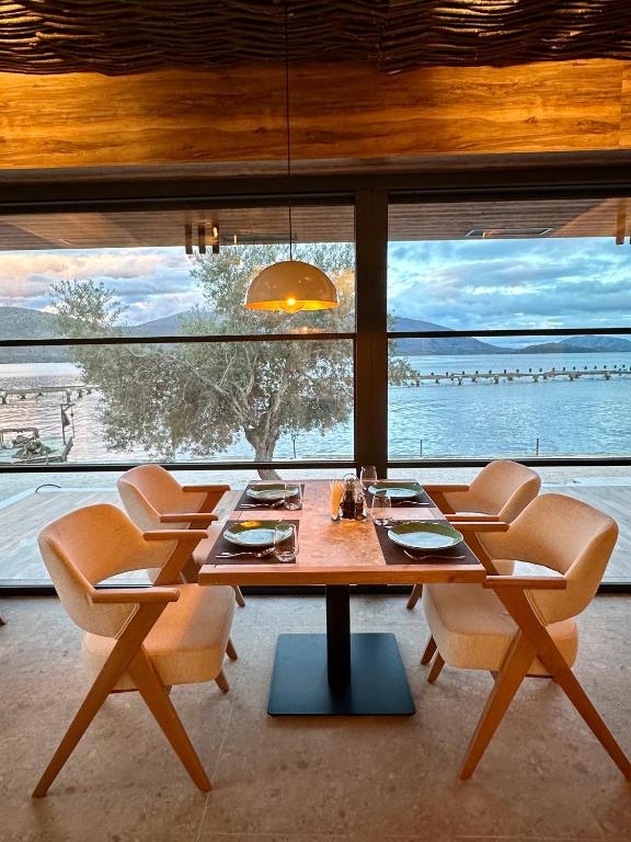 a dining room with a table and chairs and a large window at The Mussel House in Ksamil