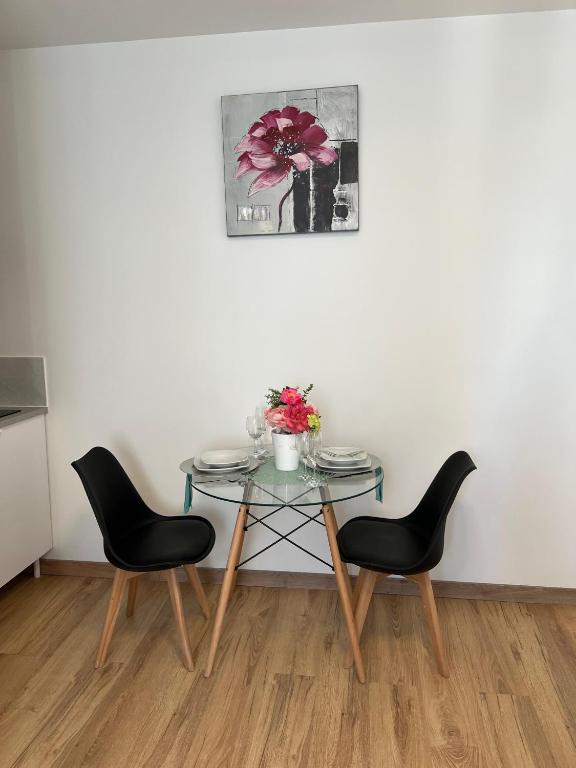 a table with two chairs and a vase with flowers on it at TherezAss Holiday in Calais