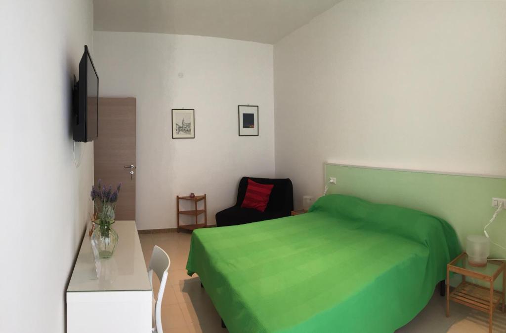 Un dormitorio con una cama verde y una silla en B&B Sorgente 23, en Salerno