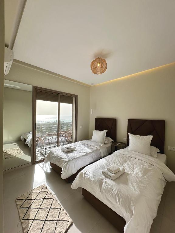 阿加迪尔Appartement vue océan的一间带两张床的卧室和一个阳台