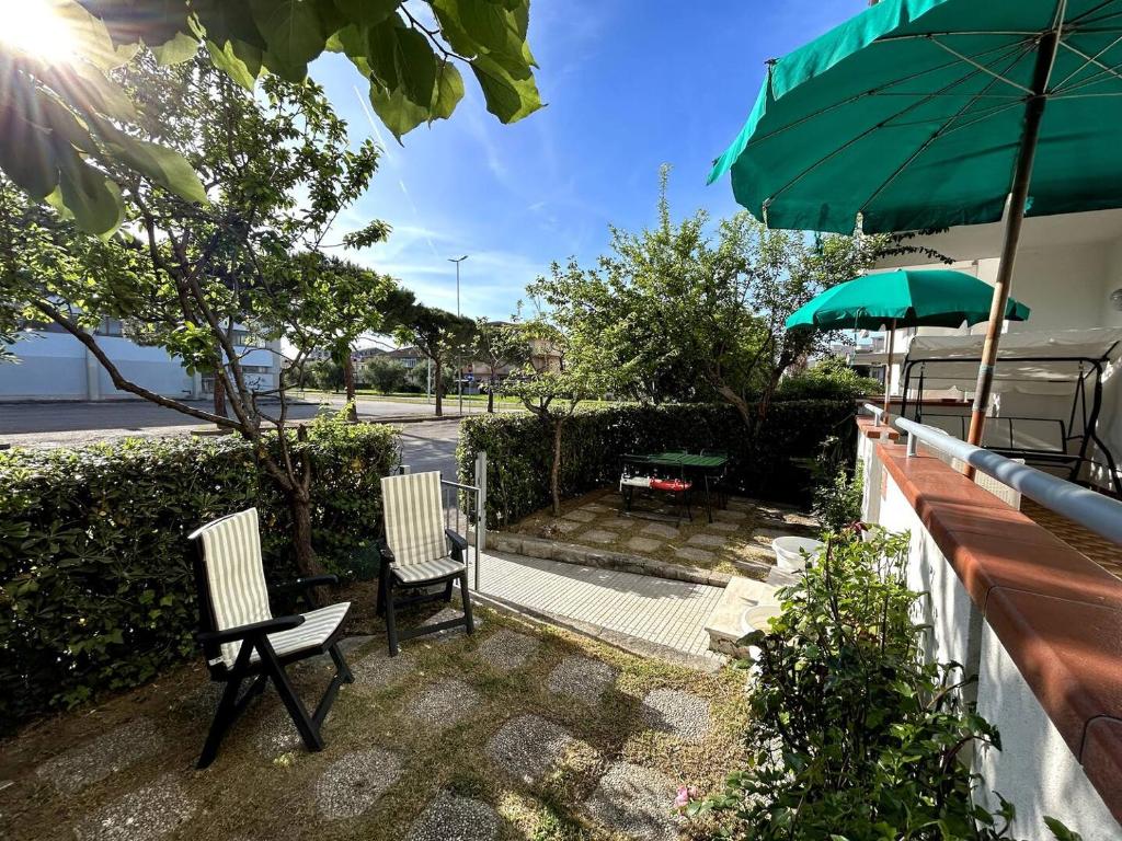 two chairs and an umbrella next to a table at ModernShore - Garden Hideaway in Alba Adriatica