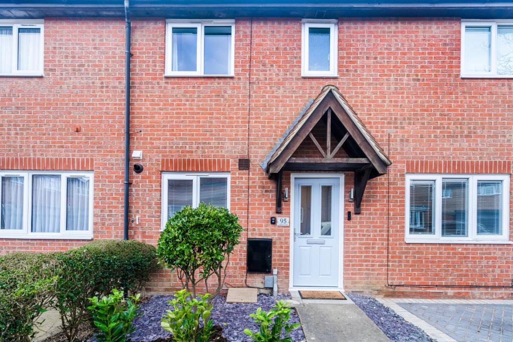 a red brick house with a white door at Recently refurbished 2 Bed Elegant home with Parking in Harlow in Harlow