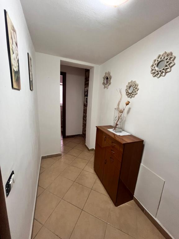 a hallway with white walls and a wooden cabinet at House del Corso Calatafimi in Palermo