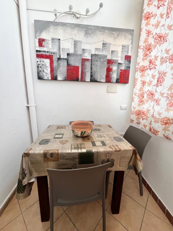 a table in a room with a painting on the wall at House del Corso Calatafimi in Palermo