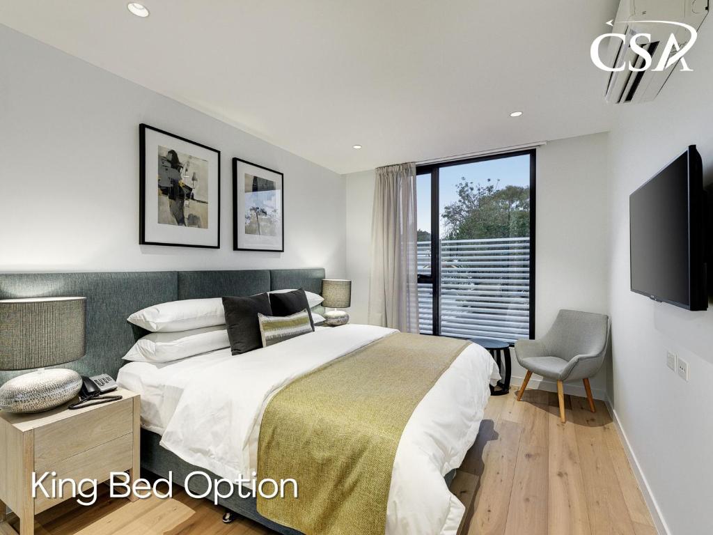 a bedroom with a king bed and a tv at Camberwell Serviced Apartments in Melbourne