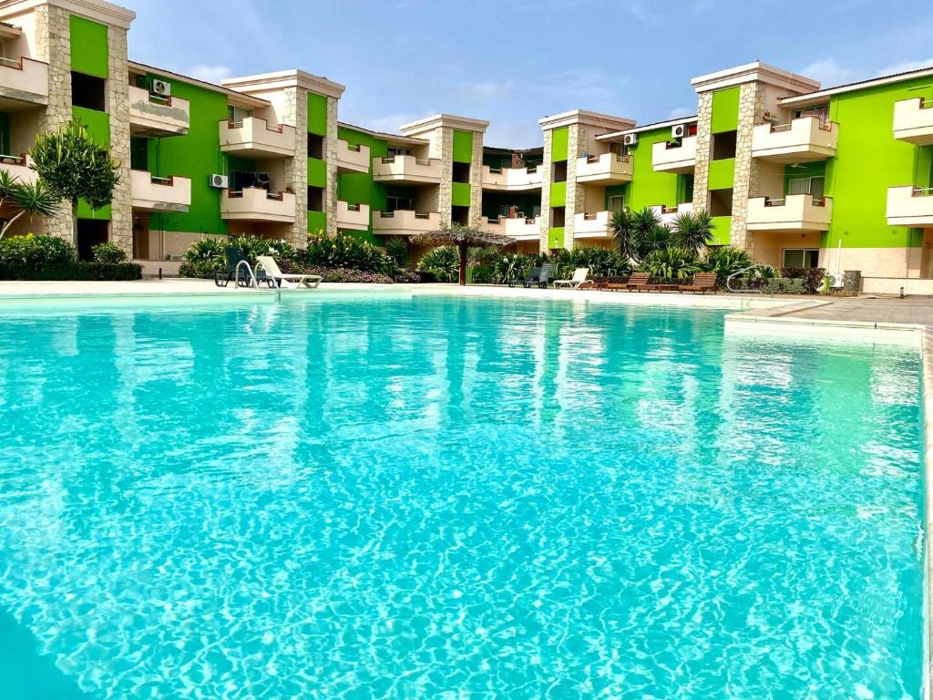 a large swimming pool in front of a building at Djadsal Moradias - by Bobbywashere in Santa Maria