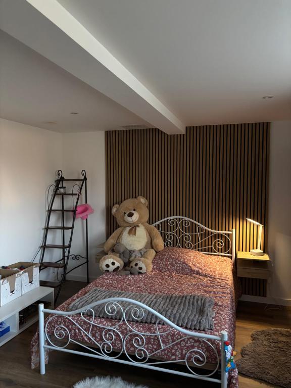 un ours en peluche assis sur un lit dans l'établissement la maison de Etienne, à Chaux