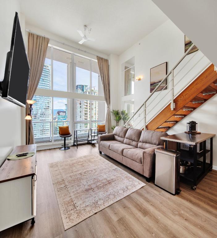 a living room with a couch and a table at Two-Story Loft with a High-rises view and Rooftop Deck in Vancouver