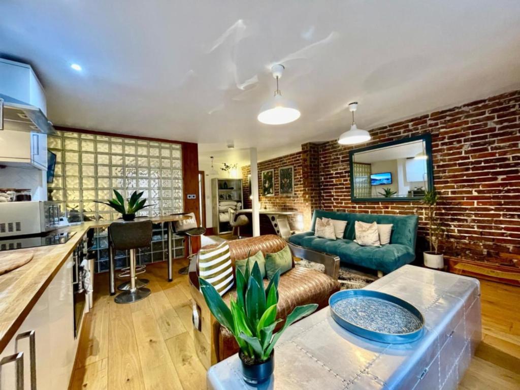 a kitchen and living room with a brick wall at By The Beach Large Central Stylish Studio for 4 Guests in Brighton & Hove