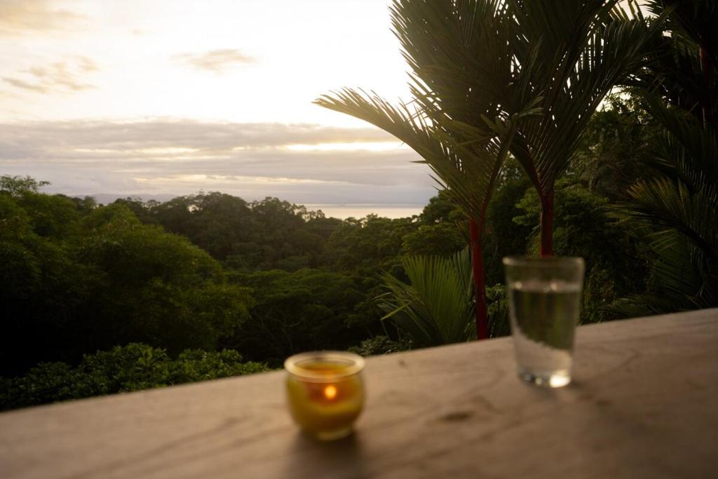 a candle and a glass sitting on a table at Puravidovo, ocean view, hill side in Golfito
