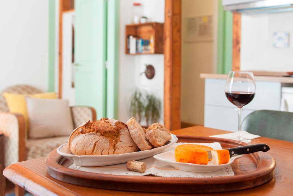 a table with a plate of bread and a glass of wine at Apartments in Historical Lisbon in Lisbon