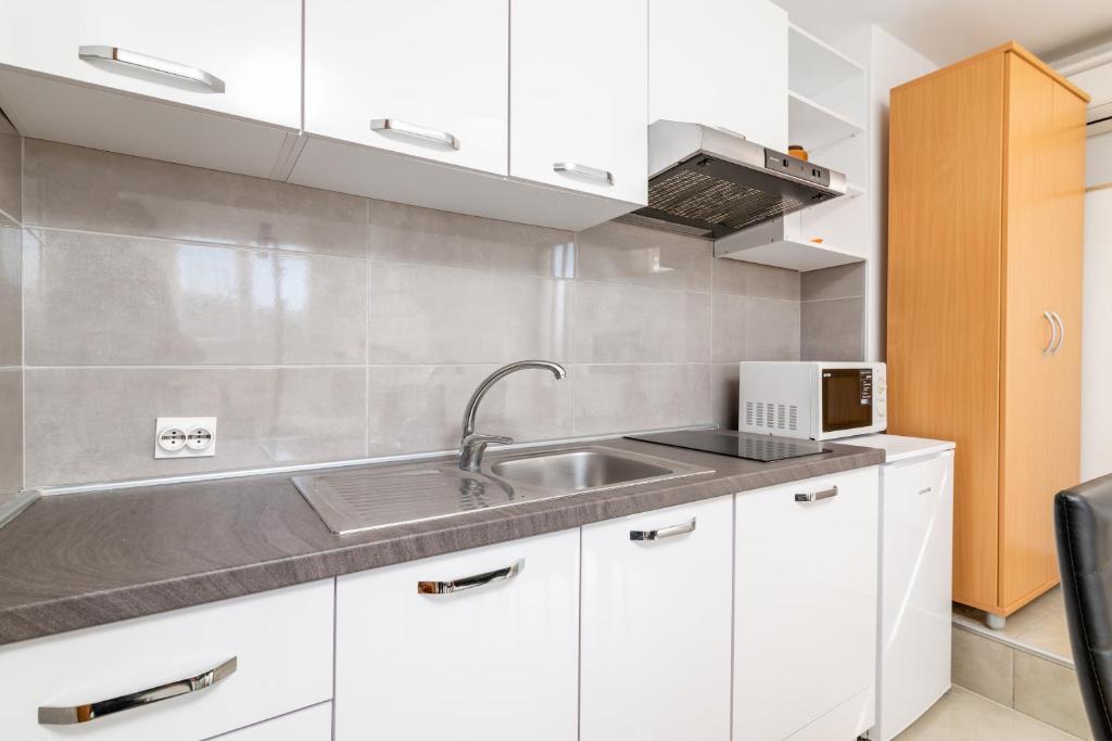 kuchnia z białymi szafkami i zlewem w obiekcie Apartments with parking spaces Rabac, Labin - 7622 w Rabacu