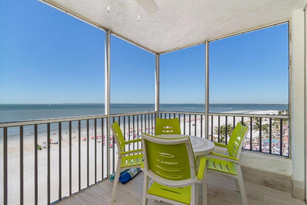 a table and chairs on a balcony with a view of the beach at Beach Villas 706 Top-Floor Condo with Gulf Views, Pool condo in Fort Myers Beach
