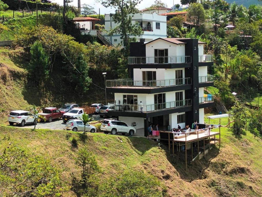 a building on a hill with cars parked in a parking lot at Villa Maru in El Peñol