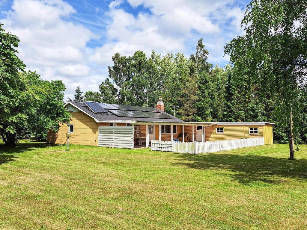 a yellow house in a field with a yard at 6 person holiday home in Storvorde in Storvorde