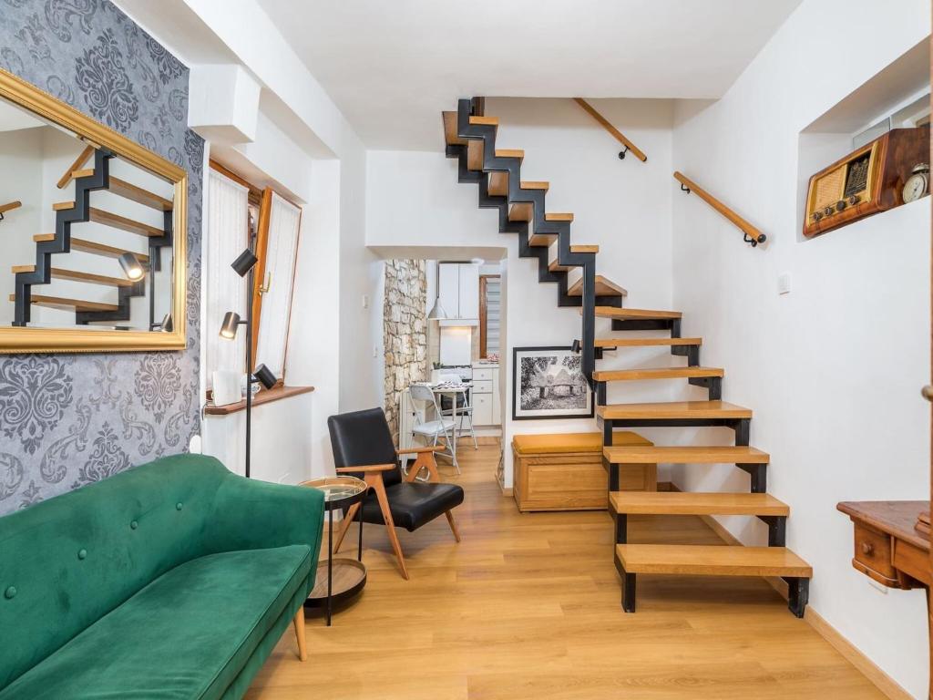 a living room with a green couch and stairs at House in Fa ana near Rock Beach in Fažana
