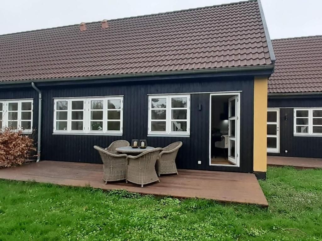 a house with a deck with a table and chairs at 5 star holiday home in Liseleje in Liseleje