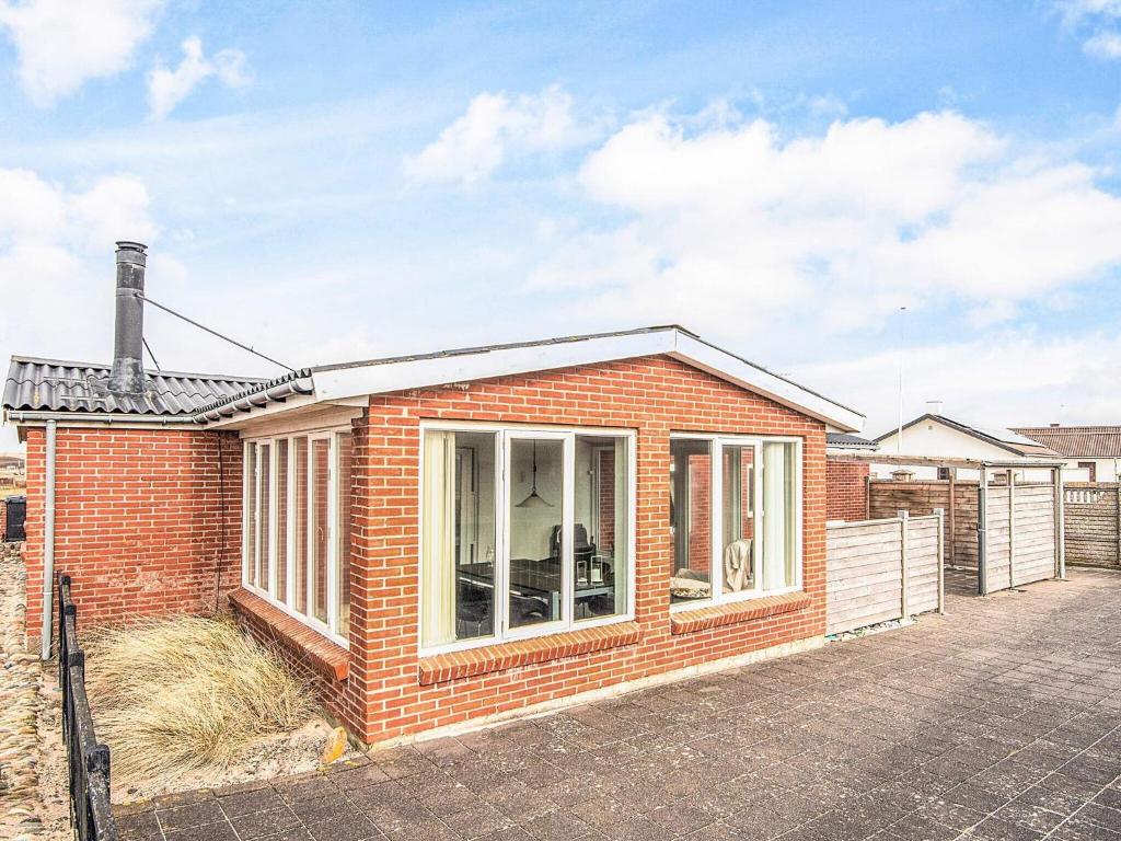 a red brick house with a large window at 8 person holiday home in Ulfborg in Ulfborg