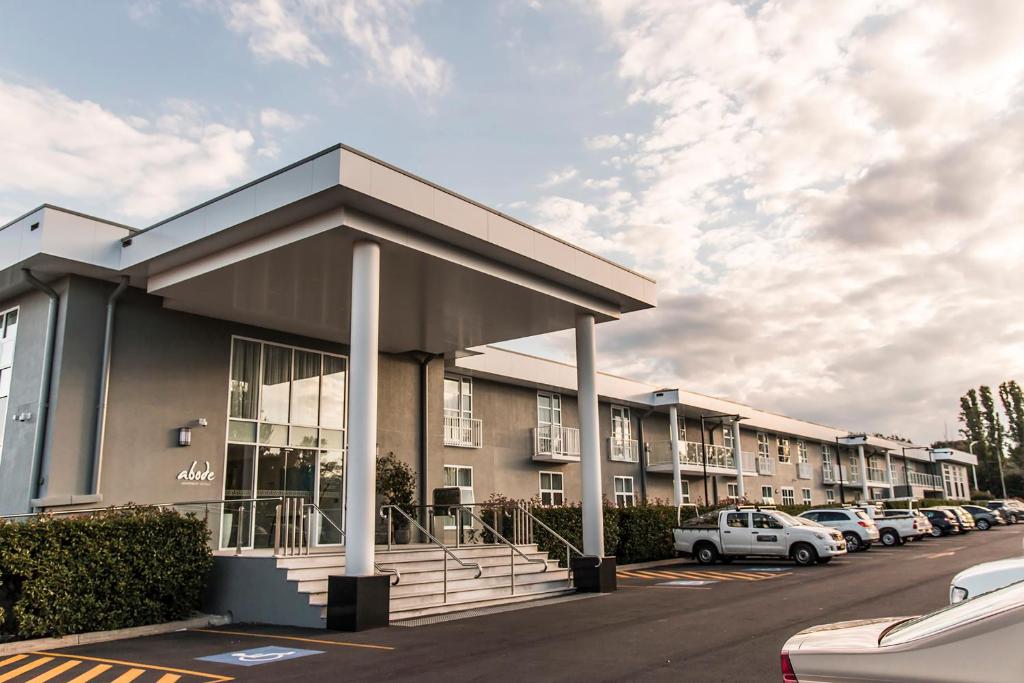 a building with cars parked in a parking lot at Abode Narrabundah in Canberra