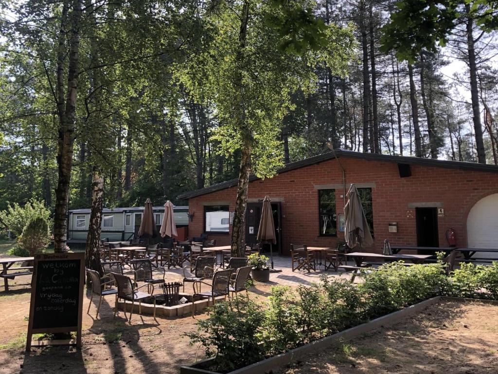 a building with tables and chairs in front of it at Chalet Escape in Antwerp in Beulk