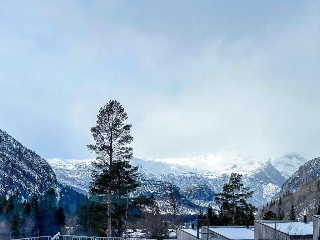 un árbol frente a una montaña cubierta de nieve en 4 star holiday home in Hemsedal, en Hemsedal