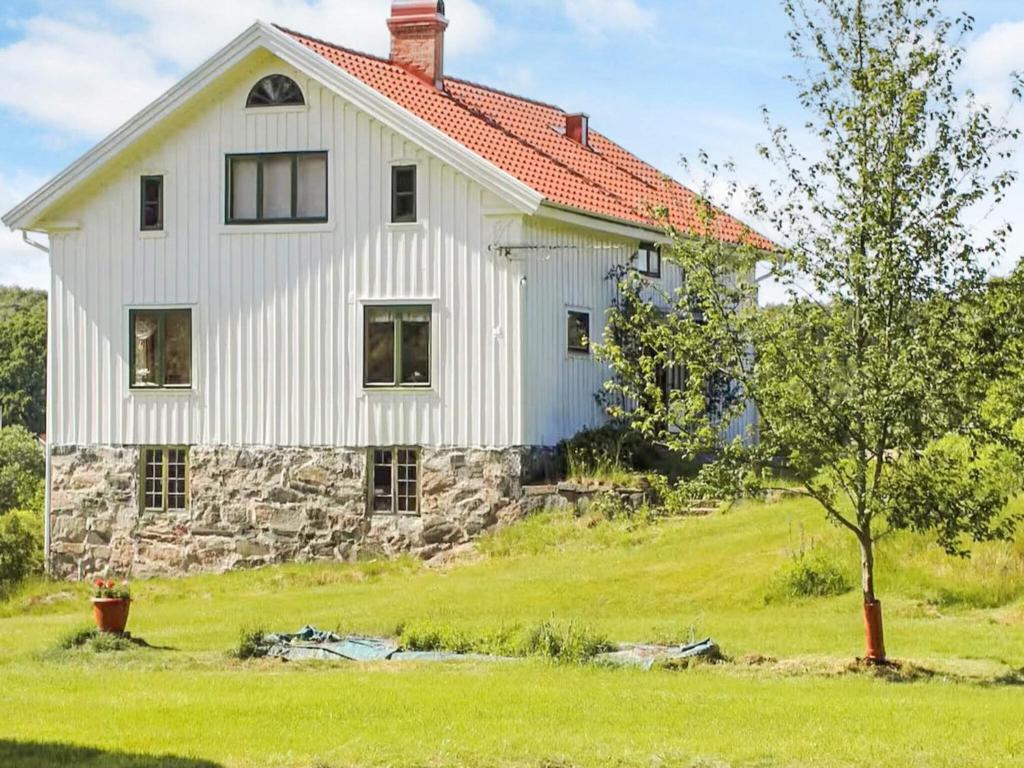 a white house on a hill with a tree at 4 star holiday home in UDDEVALLA in Fiskebäckskil