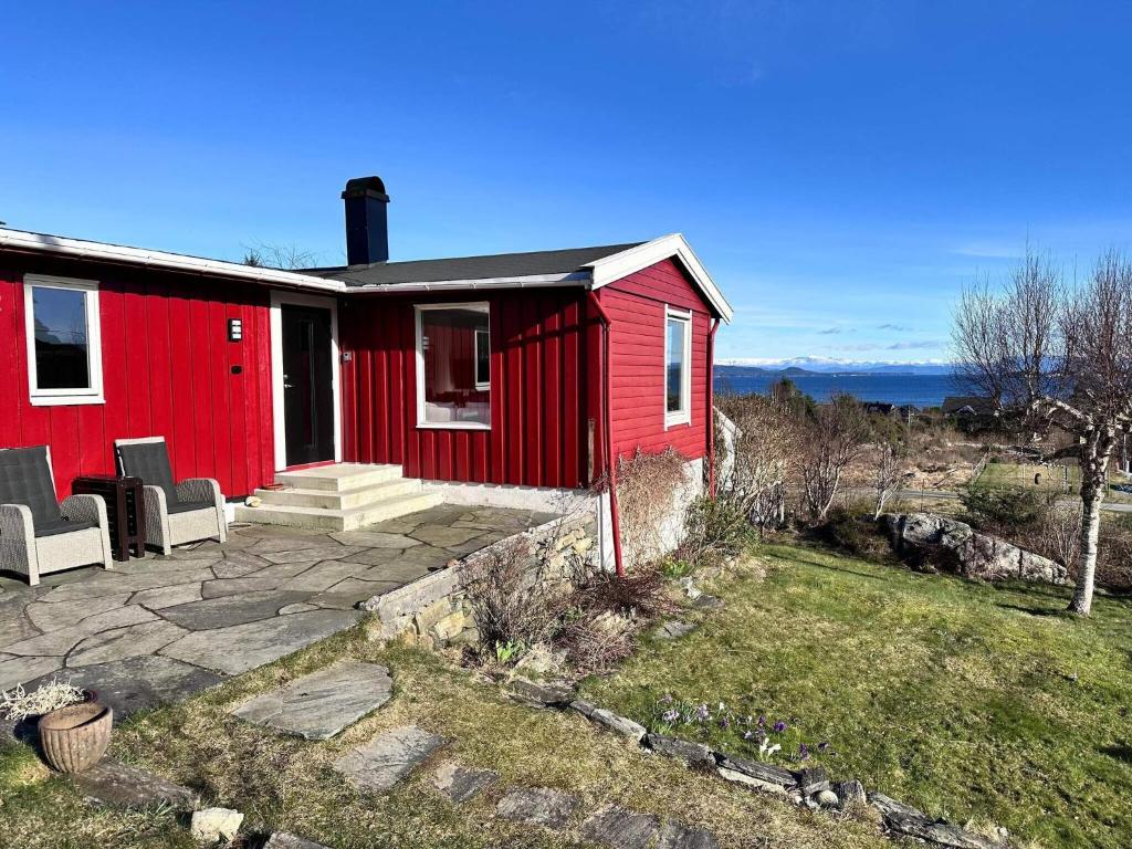 una casa rossa in cima a un campo di 6 person holiday home in KLOKKARVIK a Klokkarvik