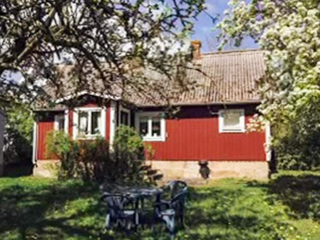 a red house with a table in front of it at 4 person holiday home in KÖPINGSVIK in Köpingsvik