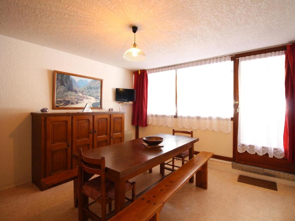 une salle à manger avec une table et des chaises en bois dans l'établissement Appartement F2 au pied des pistes avec balcon, parking et local à skis - FR-1-415-62, à Le Mont-Dore