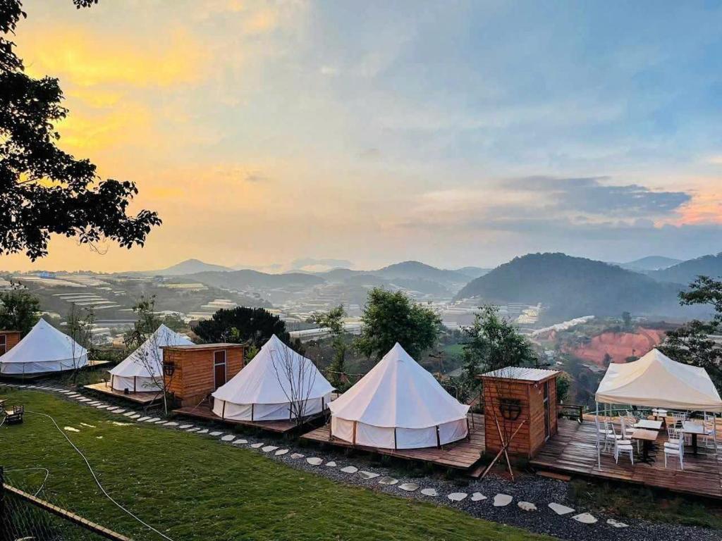 a group of tents with mountains in the background at DaLart Glamping & Coffee in Ấp Ða Lôc