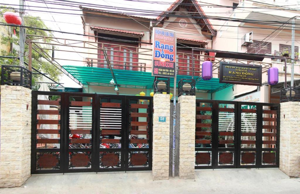 un edificio con un garaje con puertas y letreros. en Sunrise Homestay, en Hoi An