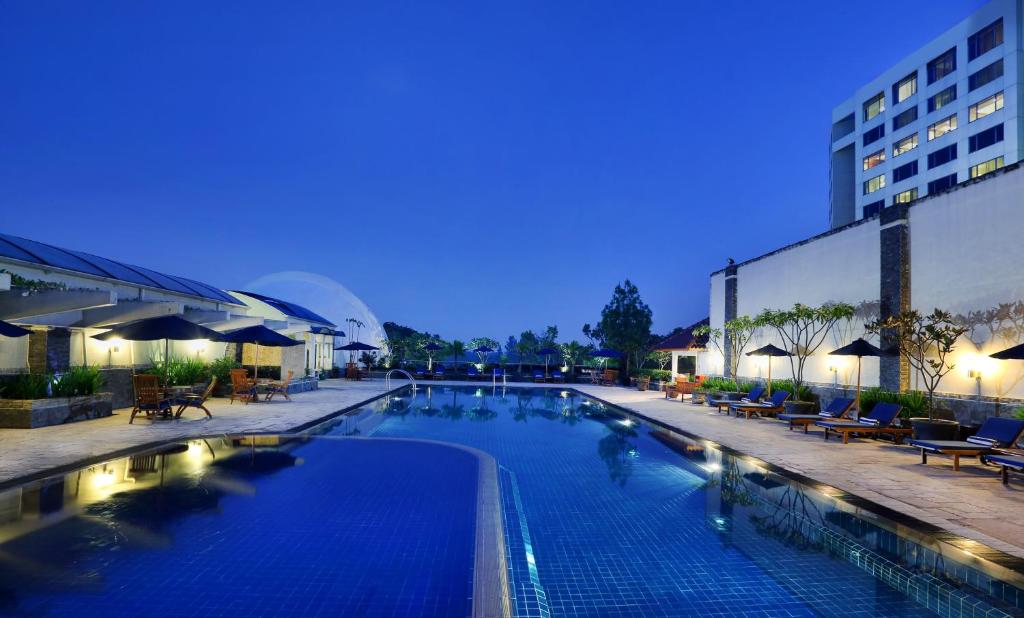 a swimming pool at a hotel at night at Aryaduta Bandung in Bandung