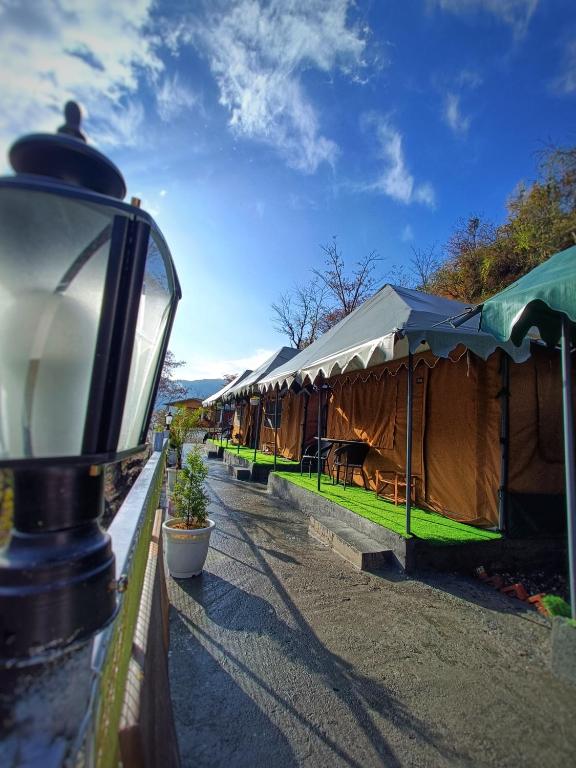a row of tents with tables and a street light at Palki Camps and Resorts in Kailāna