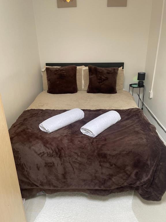 a bedroom with a bed with two pillows on it at Nestly Nook in New Cross in London