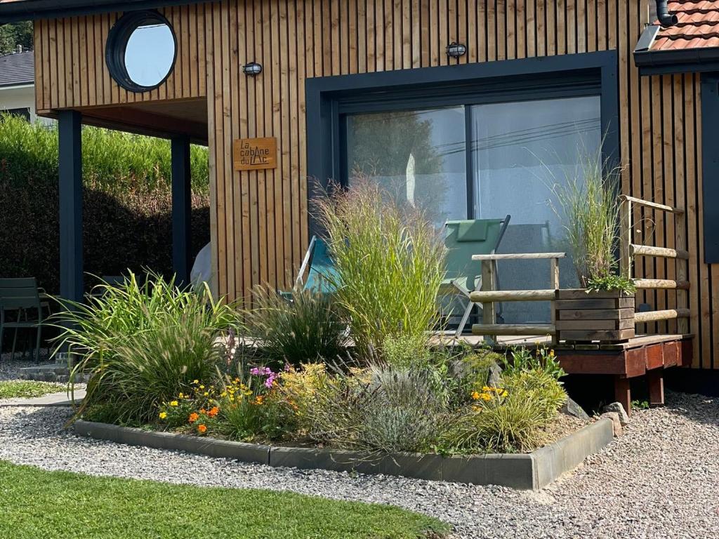 un jardin avec des plantes devant une maison dans l'établissement Maison au bord du lac pour 4 pers. + enfants, nature et tranquillité, animaux admis - FR-1-589-803, à Sanchey