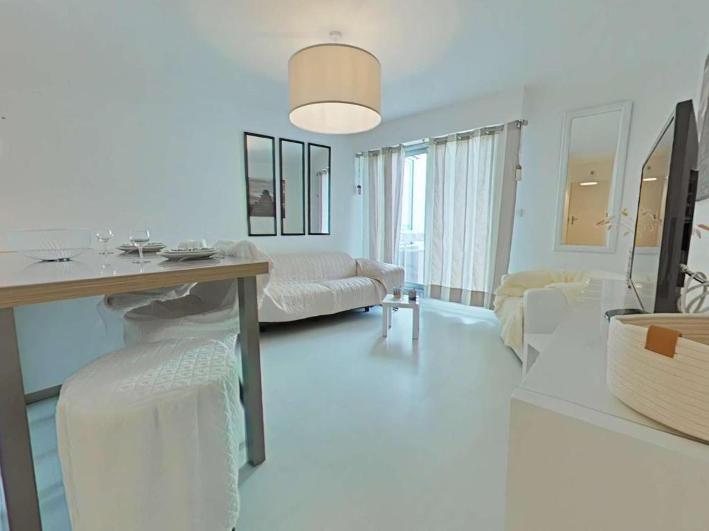 un salon blanc avec une table et des chaises dans l'établissement Charmant 2 pièces vue mer à Saint Gilles Croix de Vie - FR-1-224-817, à Saint-Gilles-Croix-de-Vie