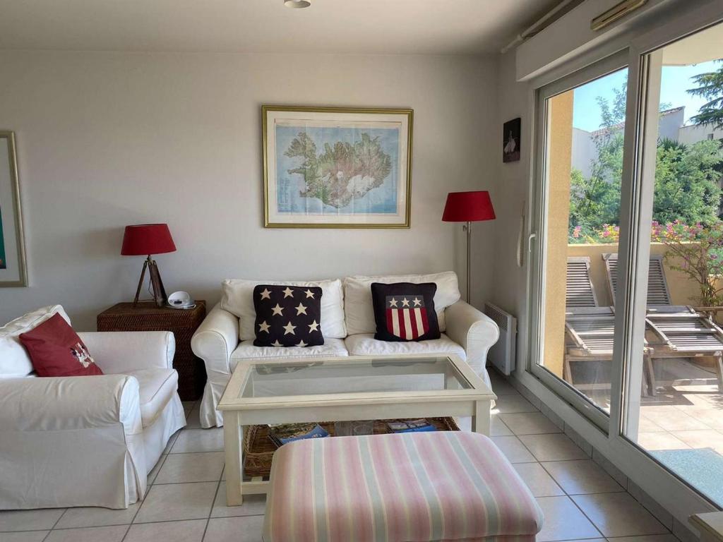un salon avec un canapé et une table dans l'établissement Appartement 2 pièces avec terrasse et piscine - 4 pers - Cannes - FR-1-609-111, à Cannes
