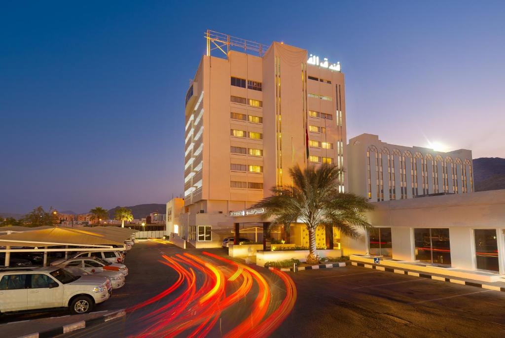 a city street with cars driving past a hotel at Al Falaj Hotel in Muscat