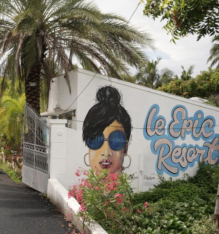 a mural of a woman with sunglasses on a wall at Le Epic Resort in Virāmpattinam