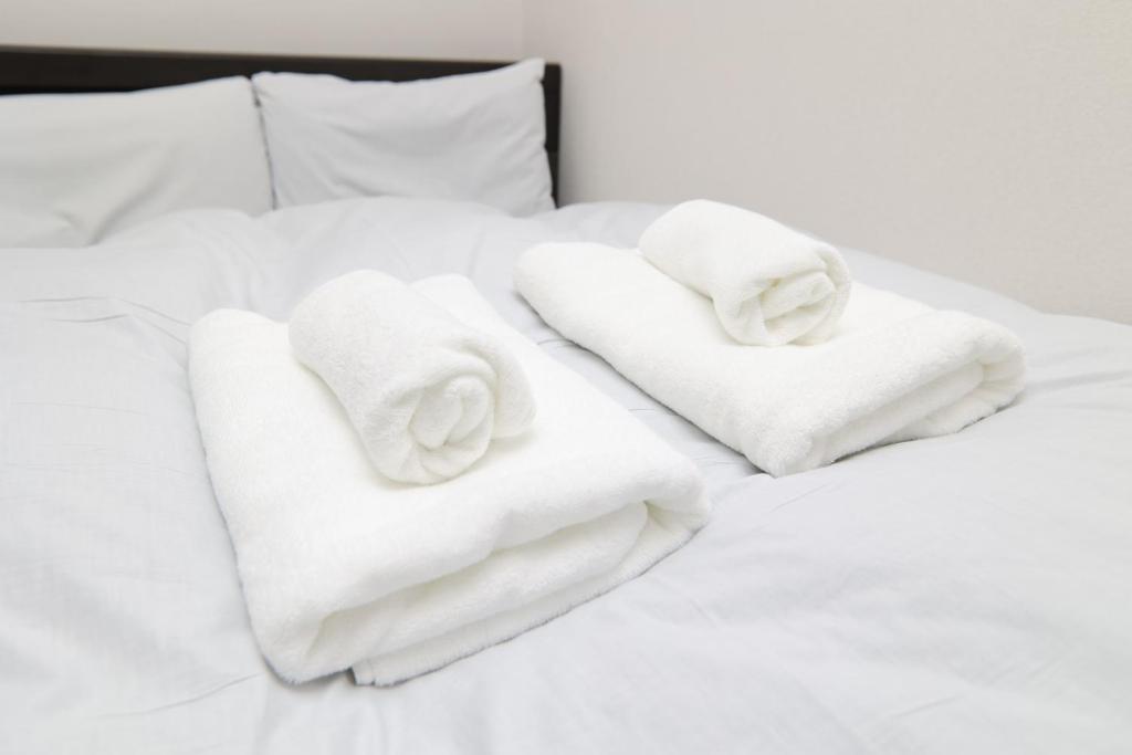 a pile of towels sitting on top of a bed at SOKOResort Hayama in Yokosuka