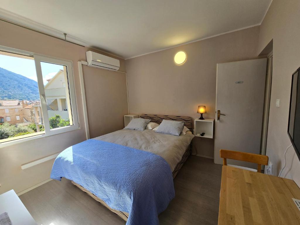 a bedroom with a bed and a large window at Bed and Breakfast BLUE in BLUE, Room GREEN + in Komiža